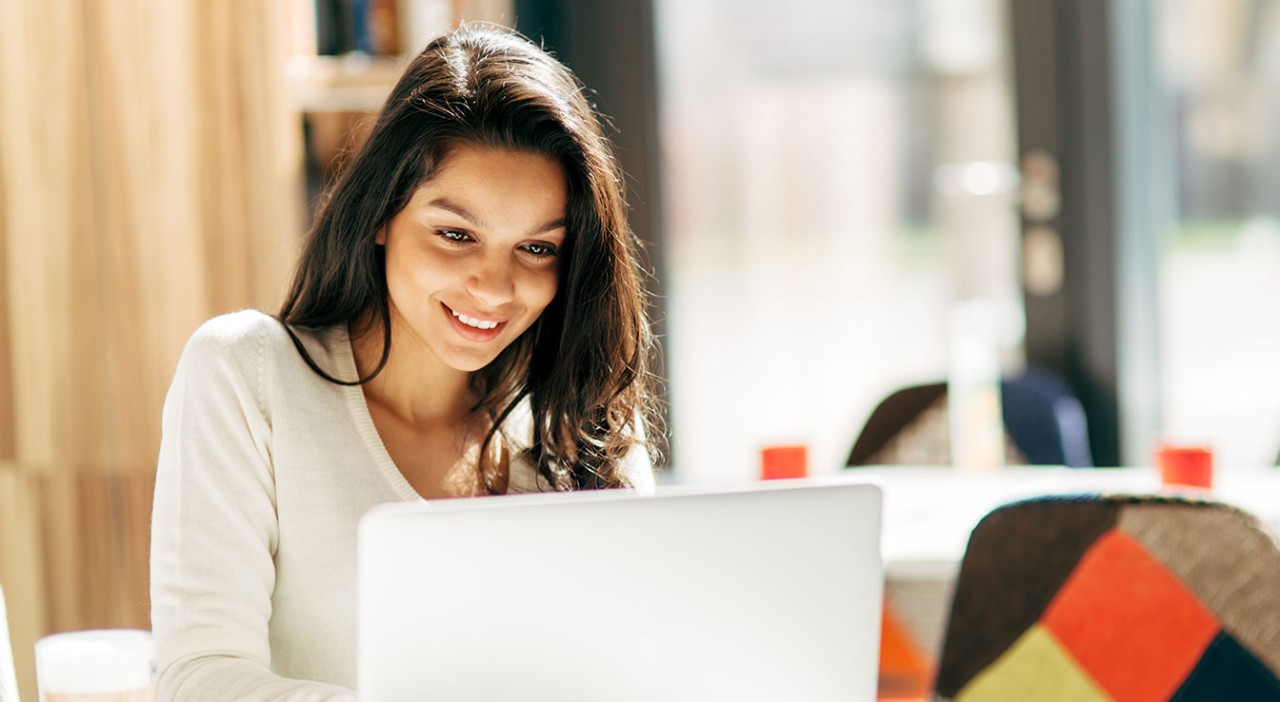 Woman smiling while typing on her laptop