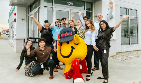 Smiley Ball, the iconic yellow mascot of the Worcester Red Sox, happily poses in front of a Worcester DCU branch entrance with DCU team members during March Member Appreciation Days.