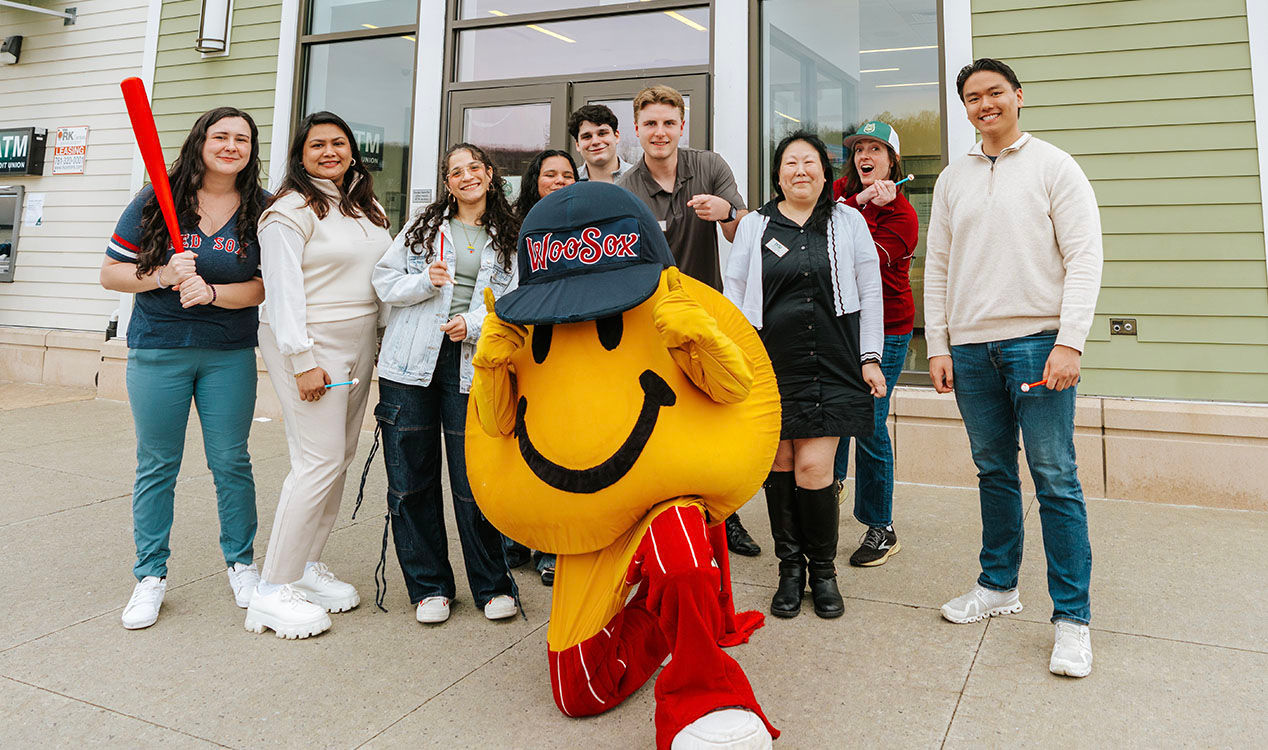 Smiley Ball, the iconic yellow mascot of the Worcester Red Sox, happily poses in front of a Worcester DCU branch entrance during March Member Appreciation Days.