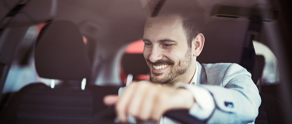 Man smiling driving car