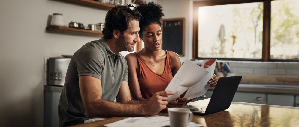 Couple sitting next to each other, reviewing their finances together