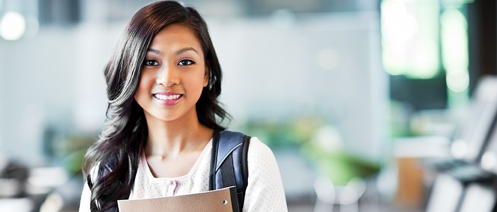 Young woman student smiling and holding notebook