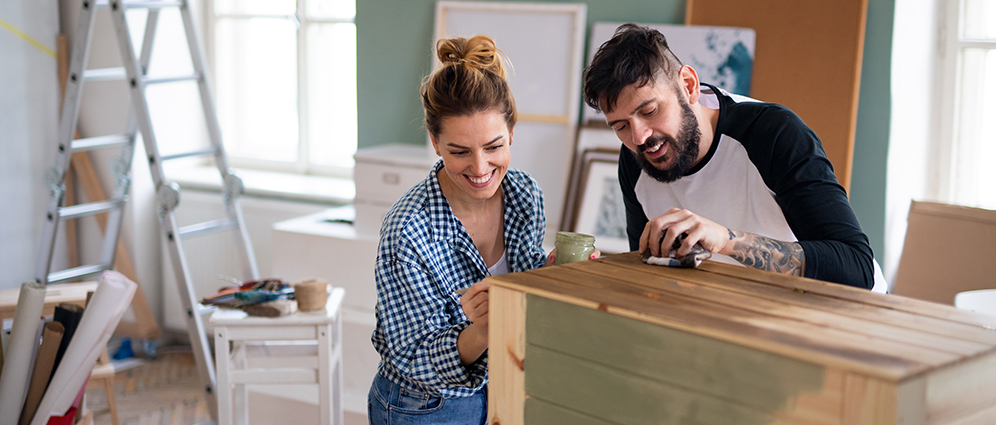 A couple painting furniture