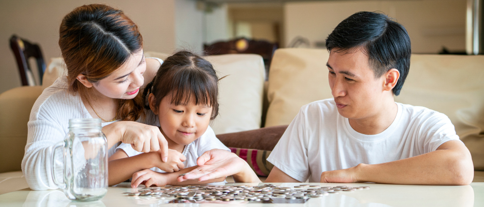 A family counting coins on a table.