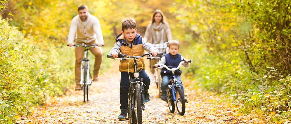 A family riding bikes together on a nature trail.
