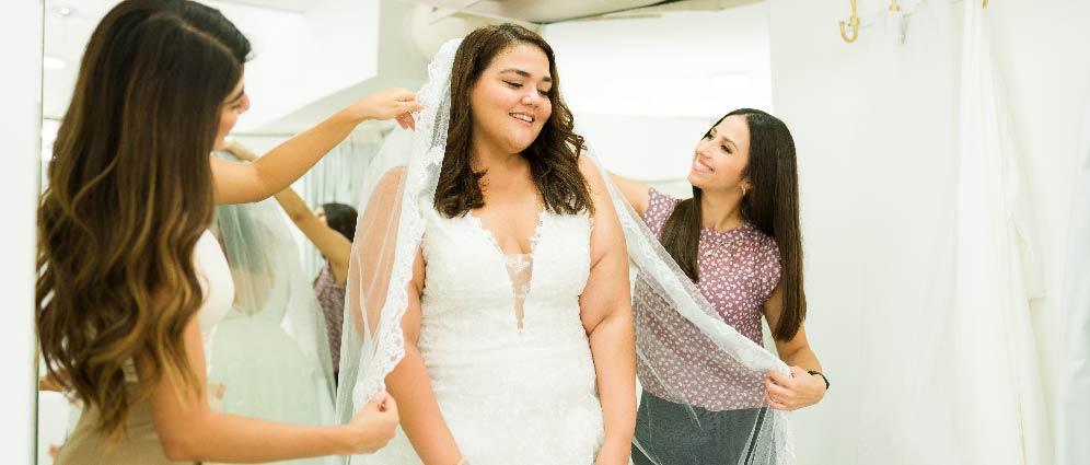 A woman trying on wedding dresses.