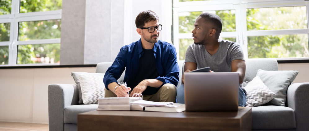 Two men talking while sitting on a couch