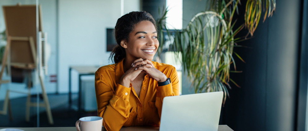 Woman smiling while working on her laptop
