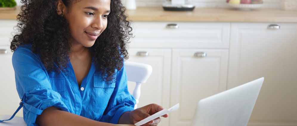 A woman smiling while using a laptop