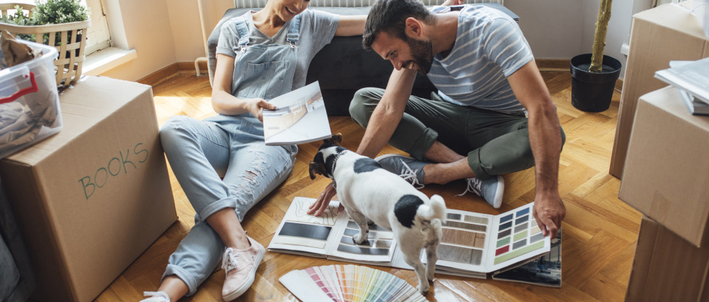 Smiling couple looking at floor samples in their home