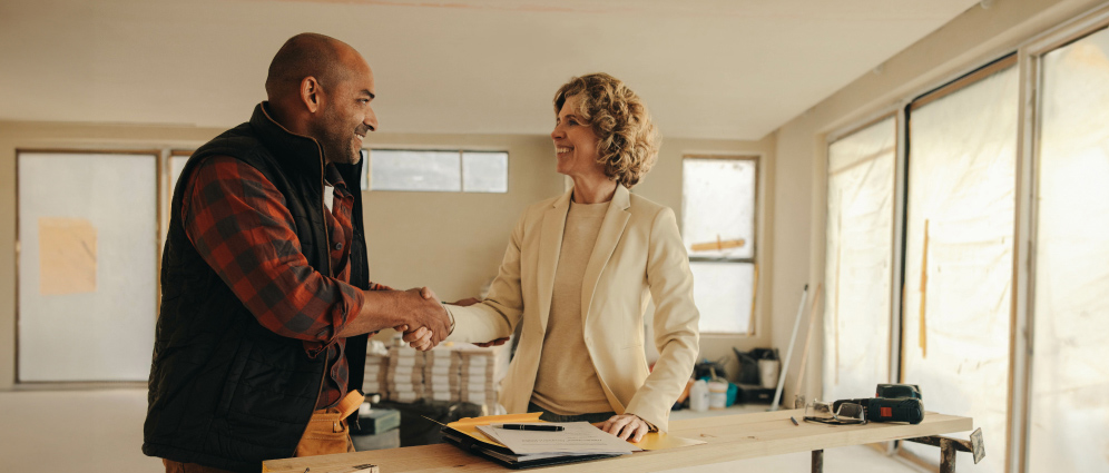 Two people shaking hands at an office desk