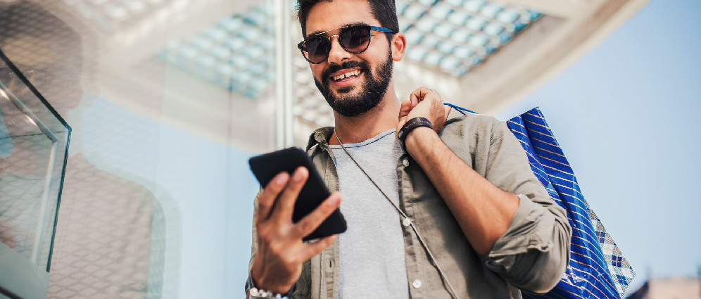 A man smiling while looking at his phone