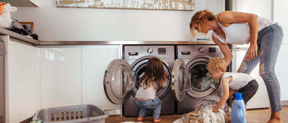 A mother doing laundry with her children