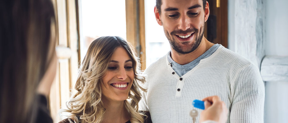 Smiling couple receiving their new house keys