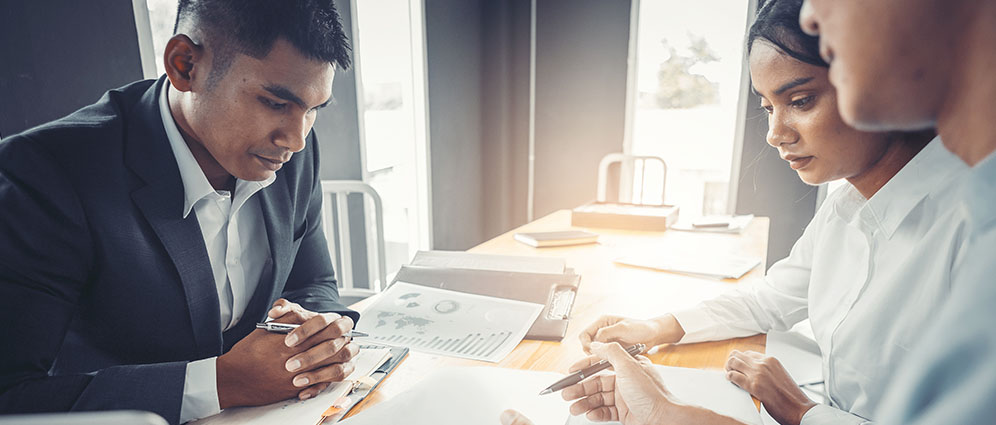 Couple reviewing paperwork with a realtor